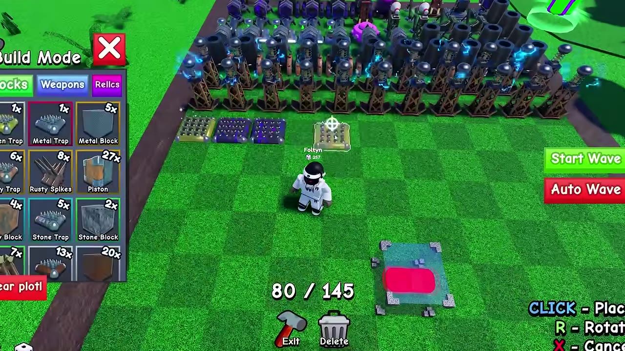 A build mode interface is open over a grassy base area filled with rows of traps, defensive towers, and block pieces, with start wave buttons on the right.