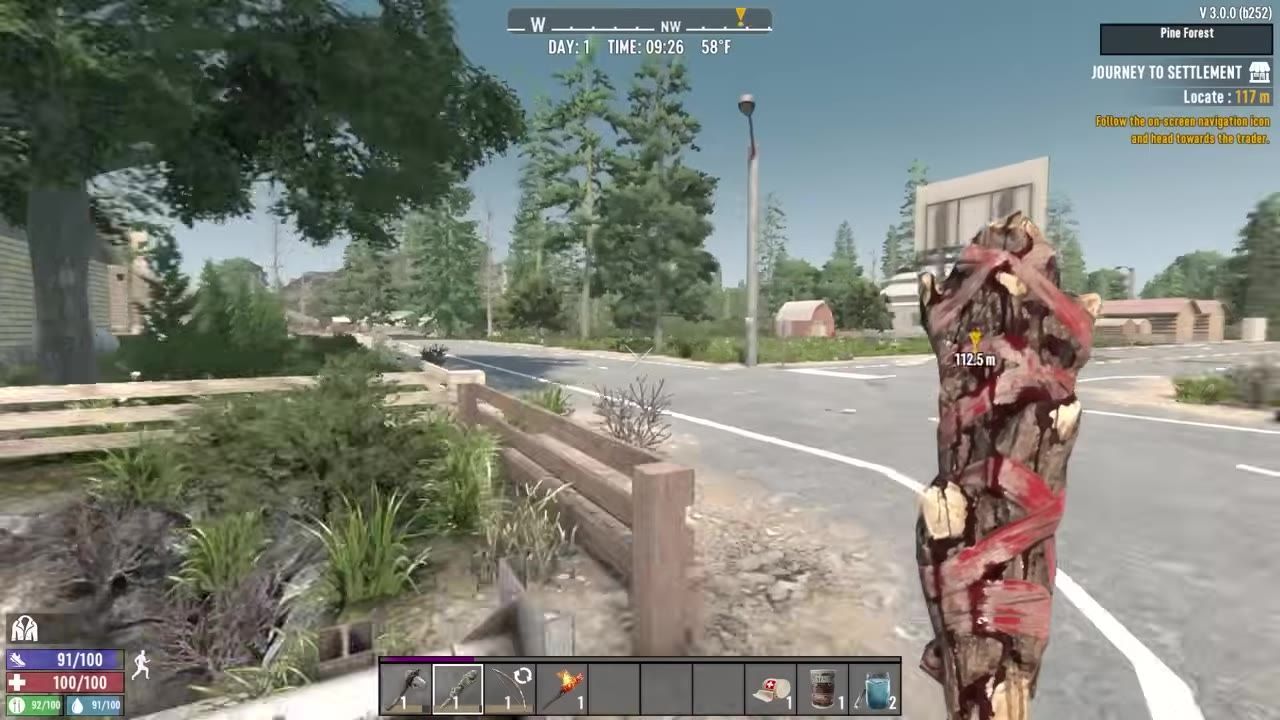 A road leading to a settlement with various structures visible in a survival video game.