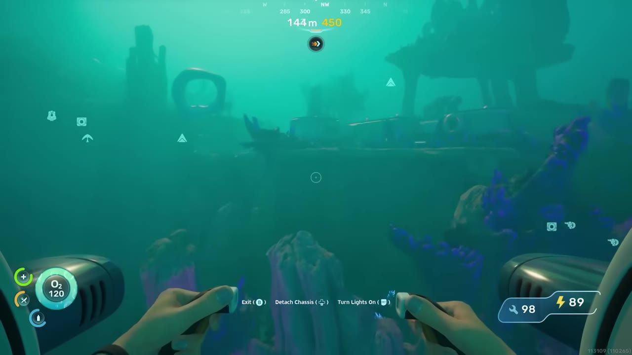 Underwater view showing a robotic arm and a large structure with surrounding objects and terrain.