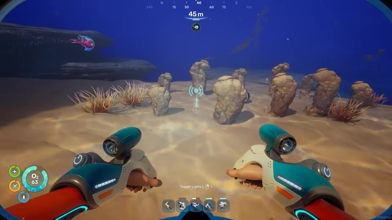 A first-person underwater view shows several rock outcrops on the seabed with the player’s hands and tool visible in the foreground.